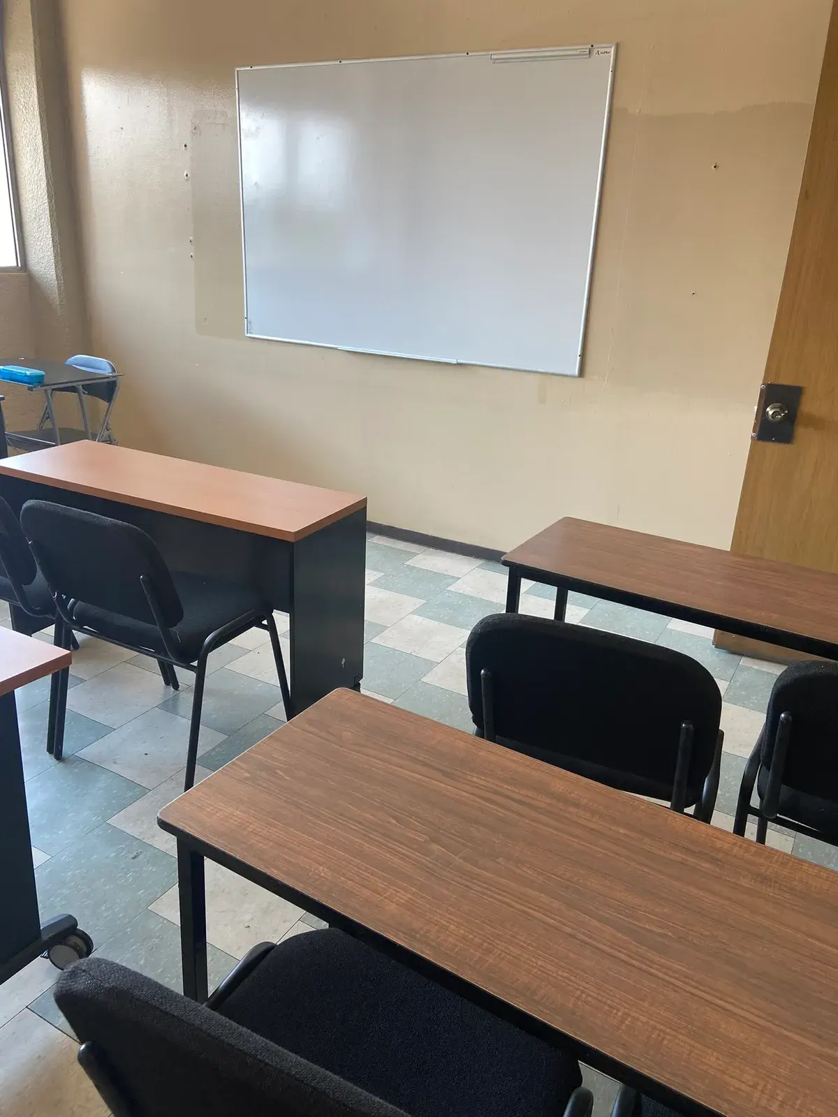 Aula de CADE con mesas de trabajo y pizarrón, iluminada con luz natural